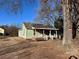 Charming one-story house with a quaint front porch and mature trees, creating a peaceful and inviting curb appeal at 2124 W C St, Kannapolis, NC 28081