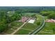Sprawling aerial view of an equestrian center featuring stables, riding arenas, and expansive green pastures for horses at 2217 Heath Lake Dr, Mint Hill, NC 28227