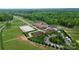 Aerial shot of horse training center featuring stables, riding arenas, and parking areas surrounded by lush greenery at 2217 Heath Lake Dr, Mint Hill, NC 28227