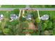 An aerial view of a home with a lush green yard, mature trees, and a long driveway in a suburban neighborhood at 2217 Heath Lake Dr, Mint Hill, NC 28227