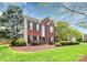 Beautiful red brick home with lush landscaping and a well-maintained green lawn at 2217 Heath Lake Dr, Mint Hill, NC 28227