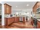Well-lit kitchen with wood floors, stainless appliances, and open dining area at 2217 Heath Lake Dr, Mint Hill, NC 28227