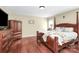 Comfortable main bedroom with a dark wood finish four poster bed and wood floors at 2217 Heath Lake Dr, Mint Hill, NC 28227