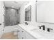 Modern bathroom featuring double sinks, a large mirror and a shower with gray stone-look tile at 2965 Beech Nut Rd, Charlotte, NC 28208