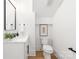 Half bathroom with white cabinet, marble countertop, black hardware, and wood-look floors at 2965 Beech Nut Rd, Charlotte, NC 28208