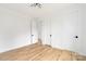 Empty bedroom with hardwood flooring, a black door, and a modern lighting fixture at 2965 Beech Nut Rd, Charlotte, NC 28208