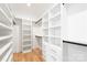 Walk-in closet featuring custom shelving, drawers, and ample storage space with hardwood floors at 2965 Beech Nut Rd, Charlotte, NC 28208