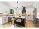 Bright kitchen with white cabinets, an island with seating, stainless steel appliances and hardwood flooring at 2965 Beech Nut Rd, Charlotte, NC 28208