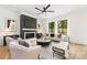 Modern living room with a fireplace, a ceiling fan, and many windows at 2965 Beech Nut Rd, Charlotte, NC 28208