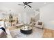 Bright living room with modern furniture, ceiling fan, and staircase featuring wood treads and black metal railings at 2965 Beech Nut Rd, Charlotte, NC 28208