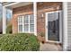 Close-up of the front entrance with a storm door, brick facade, and manicured shrubbery at 3099 Windsor Trace Dr, Fort Mill, SC 29707