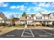Exterior view of a charming townhome with a well-manicured lawn, complemented by a convenient parking space at 3099 Windsor Trace Dr, Fort Mill, SC 29707