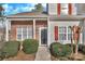 Inviting entryway with a black front door, red shutters, and trimmed shrubbery at 3099 Windsor Trace Dr, Fort Mill, SC 29707