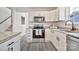 Well-lit kitchen features granite countertops, white cabinetry, stainless steel appliances and grey wood-look flooring at 3099 Windsor Trace Dr, Fort Mill, SC 29707