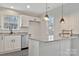 Bright kitchen view showcasing pendant lighting above granite countertop island, stainless steel appliances, and dual windows at 3099 Windsor Trace Dr, Fort Mill, SC 29707