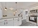 Bright kitchen view showcasing pendant lighting above granite countertop island, stainless steel range, and white cabinets at 3099 Windsor Trace Dr, Fort Mill, SC 29707