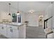 Bright open-concept living space with kitchen island, sliding glass doors, access to bath, and stairway at 3099 Windsor Trace Dr, Fort Mill, SC 29707