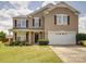 Charming two-story home boasts a well-manicured lawn, covered porch, and attached two-car garage at 3841 Shasta Cir, Clover, SC 29710