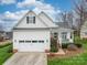 Charming two-story home featuring a pristine white exterior, well-manicured lawn, and a welcoming front porch at 4032 River Falls Dr, Lowell, NC 28098