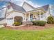 Beautiful exterior view of a bright home featuring a covered porch and nicely landscaped front yard at 4032 River Falls Dr, Lowell, NC 28098