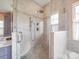 A walk-in shower featuring beautiful tilework, a shower bench and dual showerheads at 4032 River Falls Dr, Lowell, NC 28098