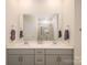 Bathroom with double vanity, gray cabinets, quartz countertops, and a glass-enclosed shower at 4321 Duplin Dr, Charlotte, NC 28214
