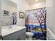 Well-lit bathroom with gray vanity, decorative mirror and shower/tub combination at 4321 Duplin Dr, Charlotte, NC 28214