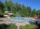 Community pool area with a splash pad and water slide, providing fun for all ages with seating and shade at 4321 Duplin Dr, Charlotte, NC 28214