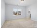 Bright bedroom featuring neutral carpet, light walls, and a view of the neighborhood at 4329 Hunton Dale Nw Rd, Concord, NC 28027
