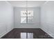 Dining room featuring dark hardwood floors, a decorative chandelier, and a large window at 4329 Hunton Dale Nw Rd, Concord, NC 28027