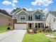Charming two-story home with manicured lawn, stone accents, and attached two car garage at 4329 Hunton Dale Nw Rd, Concord, NC 28027