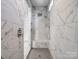 Contemporary shower with marble tile, bench, and a rainfall shower head at 4329 Hunton Dale Nw Rd, Concord, NC 28027