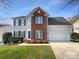 Charming two-story home with a brick facade, blue shutters, attached two-car garage, and a well-maintained lawn at 4910 Summerside Dr, Clover, SC 29710