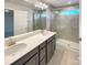 Bathroom featuring double sinks, granite countertops, and a glass-enclosed shower at 5629 Axil Ln, Charlotte, NC 28269