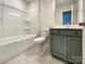 Clean bathroom featuring gray vanity with storage and a tub/shower with white surround at 5629 Axil Ln, Charlotte, NC 28269