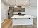 Bright kitchen with a white quartz island, gray cabinets, and stainless steel appliances at 5629 Axil Ln, Charlotte, NC 28269