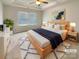 Cozy primary bedroom with a tray ceiling, large bed, and lots of natural light at 5629 Axil Ln, Charlotte, NC 28269