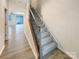 Carpeted staircase with wood railing that leads up to the second level of the home at 5629 Axil Ln, Charlotte, NC 28269