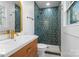 Bathroom featuring tiled shower with gold accents, vanity with sink and hardwood cabinet at 5825 Ruth Dr, Charlotte, NC 28215
