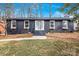 Charming single-story home featuring a dark painted brick facade and a neatly landscaped front yard at 5825 Ruth Dr, Charlotte, NC 28215