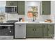 Modern kitchen with subway tile backsplash, stainless appliances, green cabinets, and white countertops at 5825 Ruth Dr, Charlotte, NC 28215