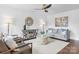 Bright living room featuring hardwood floors, neutral paint, with modern furnishings, and a decorative ceiling fan at 5825 Ruth Dr, Charlotte, NC 28215