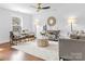 Bright living room featuring hardwood floors, neutral paint, with modern furnishings, and a decorative ceiling fan at 5825 Ruth Dr, Charlotte, NC 28215