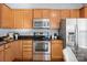 Well-equipped kitchen featuring stainless steel appliances, wood cabinets, and dark countertops at 6044 Great Basin Ln, Fort Mill, SC 29707
