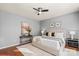 Calm main bedroom includes a ceiling fan, wood flooring, and neutral decor at 6044 Great Basin Ln, Fort Mill, SC 29707
