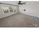 Large bedroom featuring neutral carpet, a ceiling fan, and three bright windows at 6234 Artigas Dr, Fort Mill, SC 29707