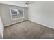Clean, carpeted bedroom featuring a ceiling fan and natural light through a single window at 6234 Artigas Dr, Fort Mill, SC 29707