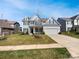 Charming two-story home with a manicured lawn and attached two-car garage at 6234 Artigas Dr, Fort Mill, SC 29707