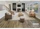 Bright living room featuring hardwood floors, a fireplace, and large windows at 6234 Artigas Dr, Fort Mill, SC 29707
