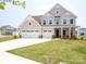 Charming two-story home featuring a three-car garage and covered front porch at 730 Autumn Sage Dr, Indian Trail, NC 28079